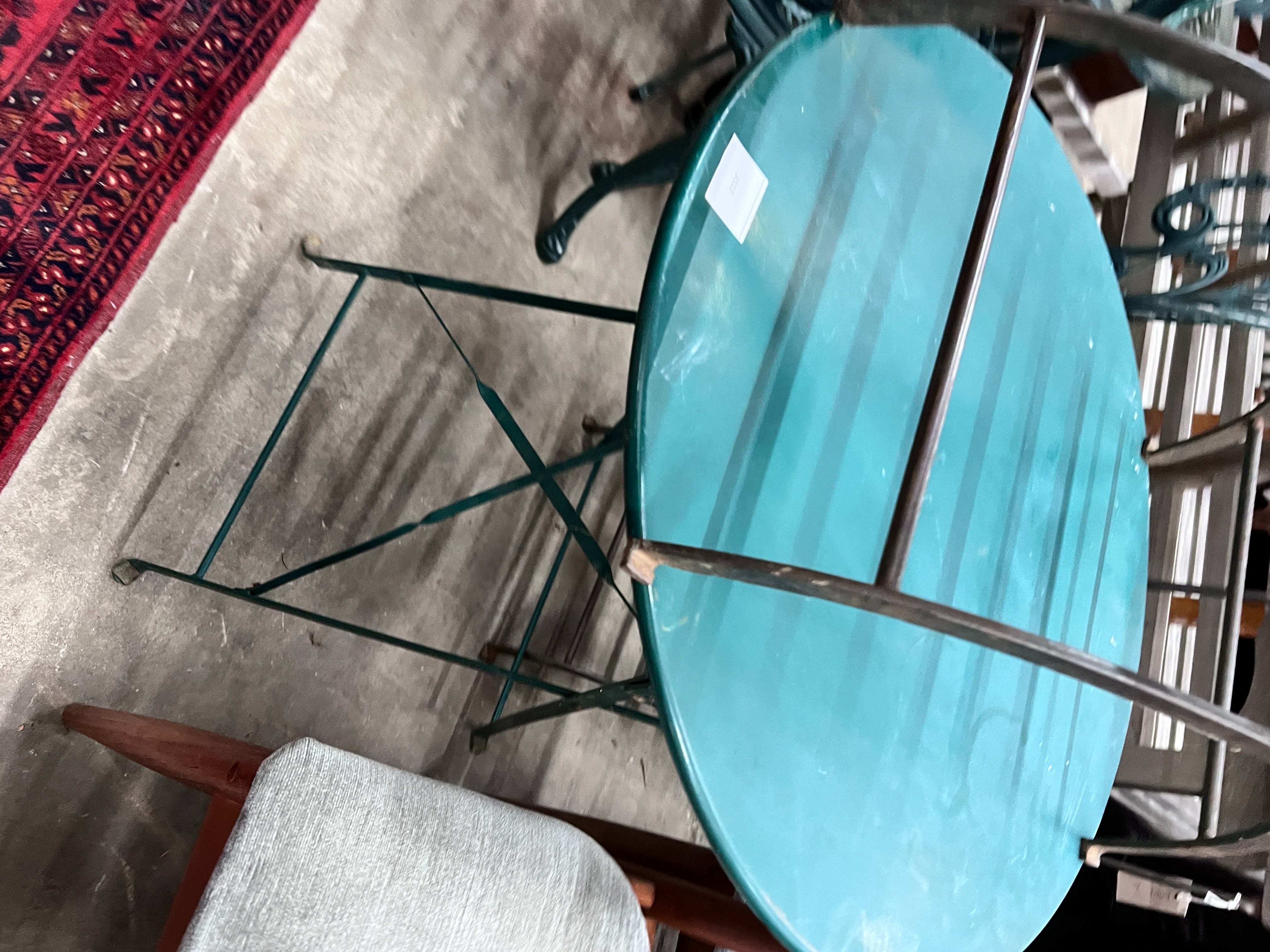 A painted metal circular folding garden table, diameter 59cm, height 70cm and two chairs
